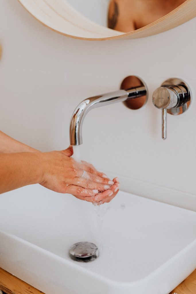 hot water system repairs sunshine coast - person washing their hands