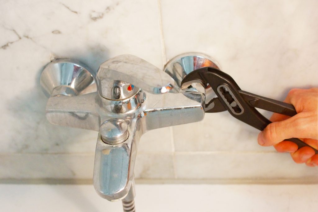 hot water system repairs sunshine coast - man fixing faucet