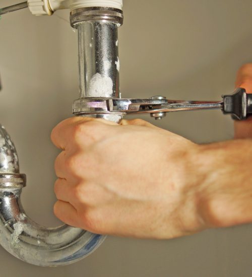 general plumber - person using tool on plumbing pipes